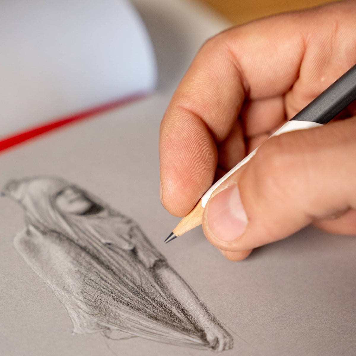 Hand drawing a detailed sketch using Blackwing Neolucida pencils on gray paper