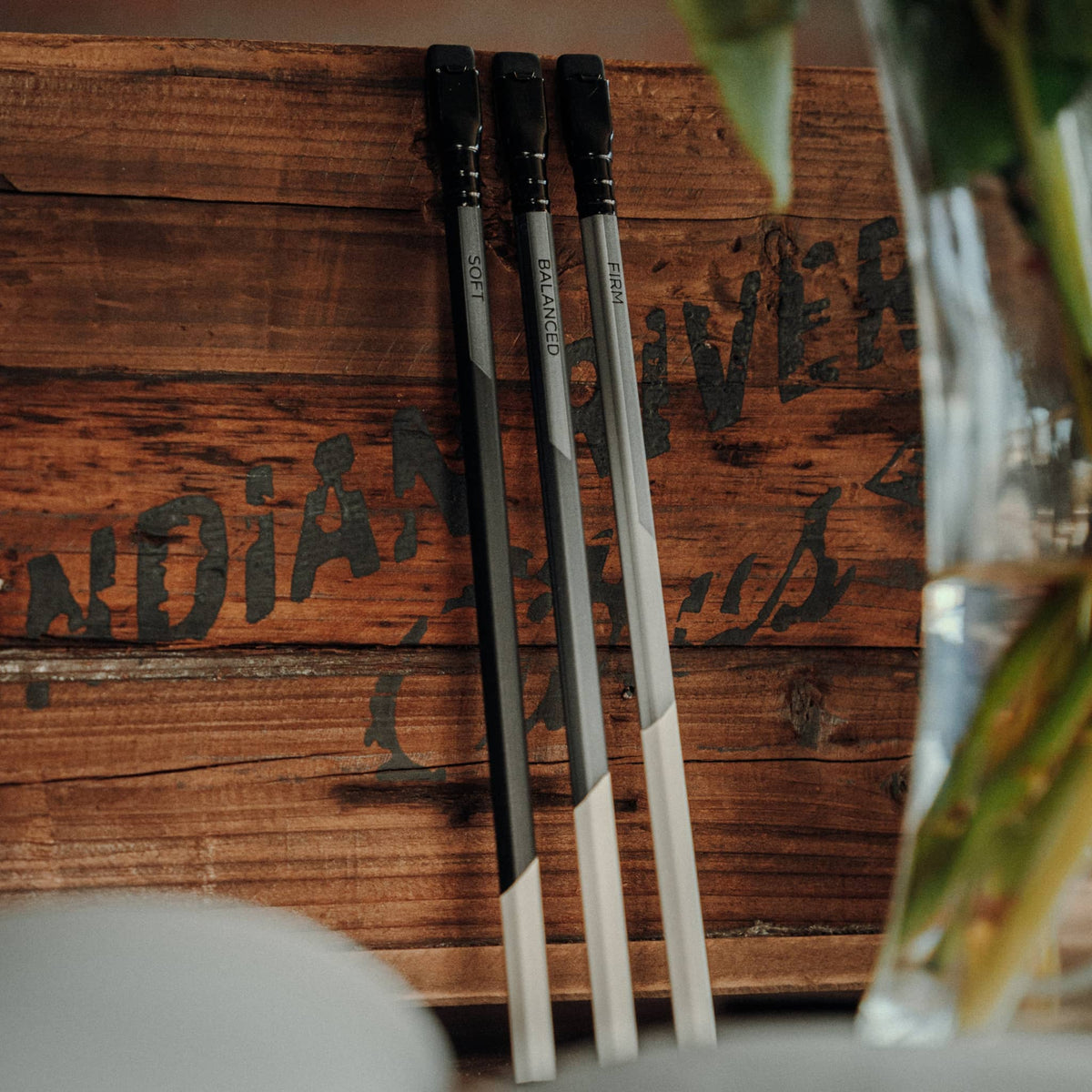 Set of three Blackwing Neolucida pencils with black and white design leaning against wooden surface