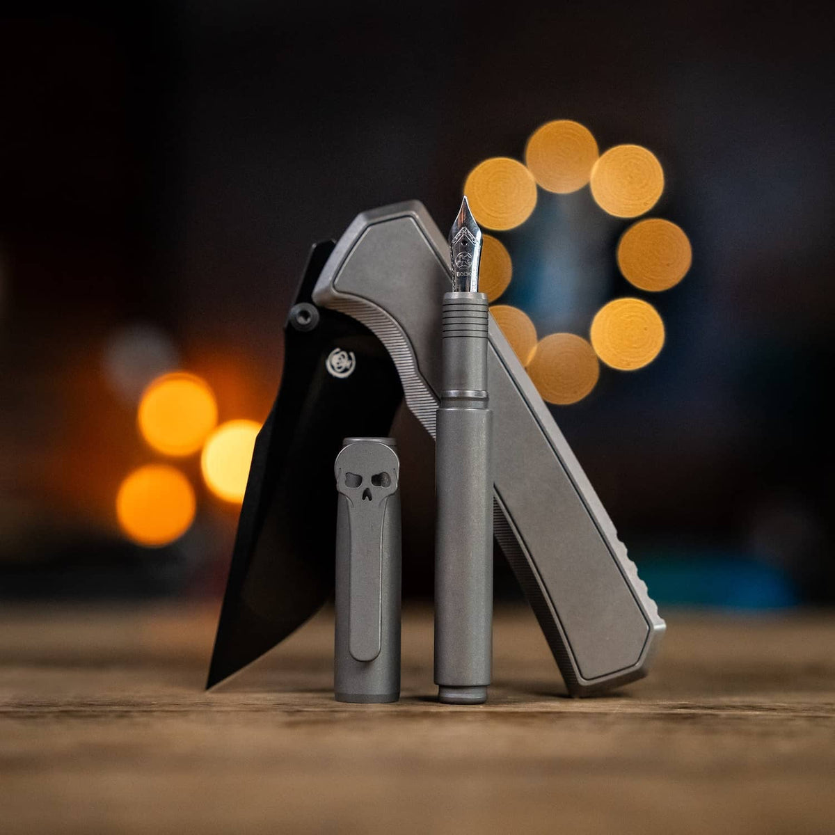 Chaves pens in gray titanium with a knife, showcasing a sleek design and detailed craftsmanship