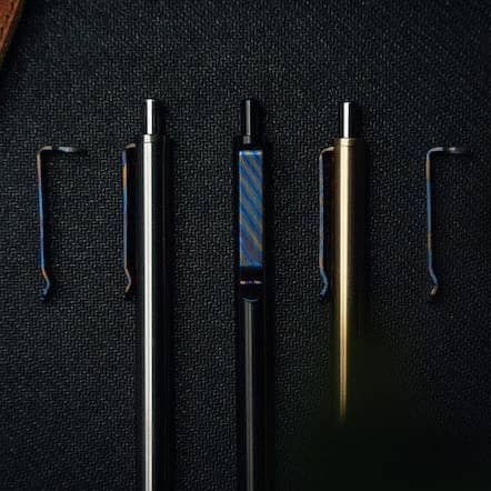 Set of three sleek pens with interchangeable Titanium Damascus pen clip by Big Idea Design LLC on black background