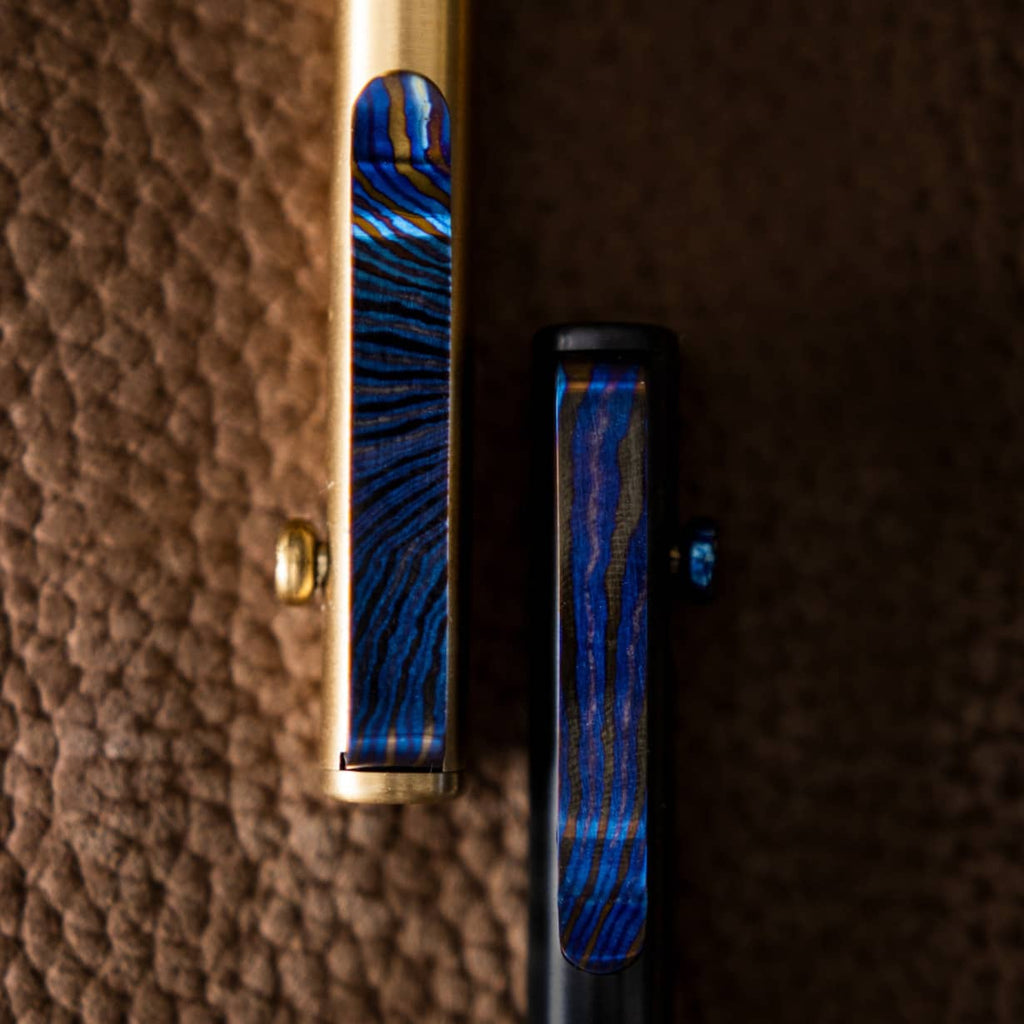 Big Idea Design LLC pens featuring a unique Titanium Damascus pen clip with blue and black patterns