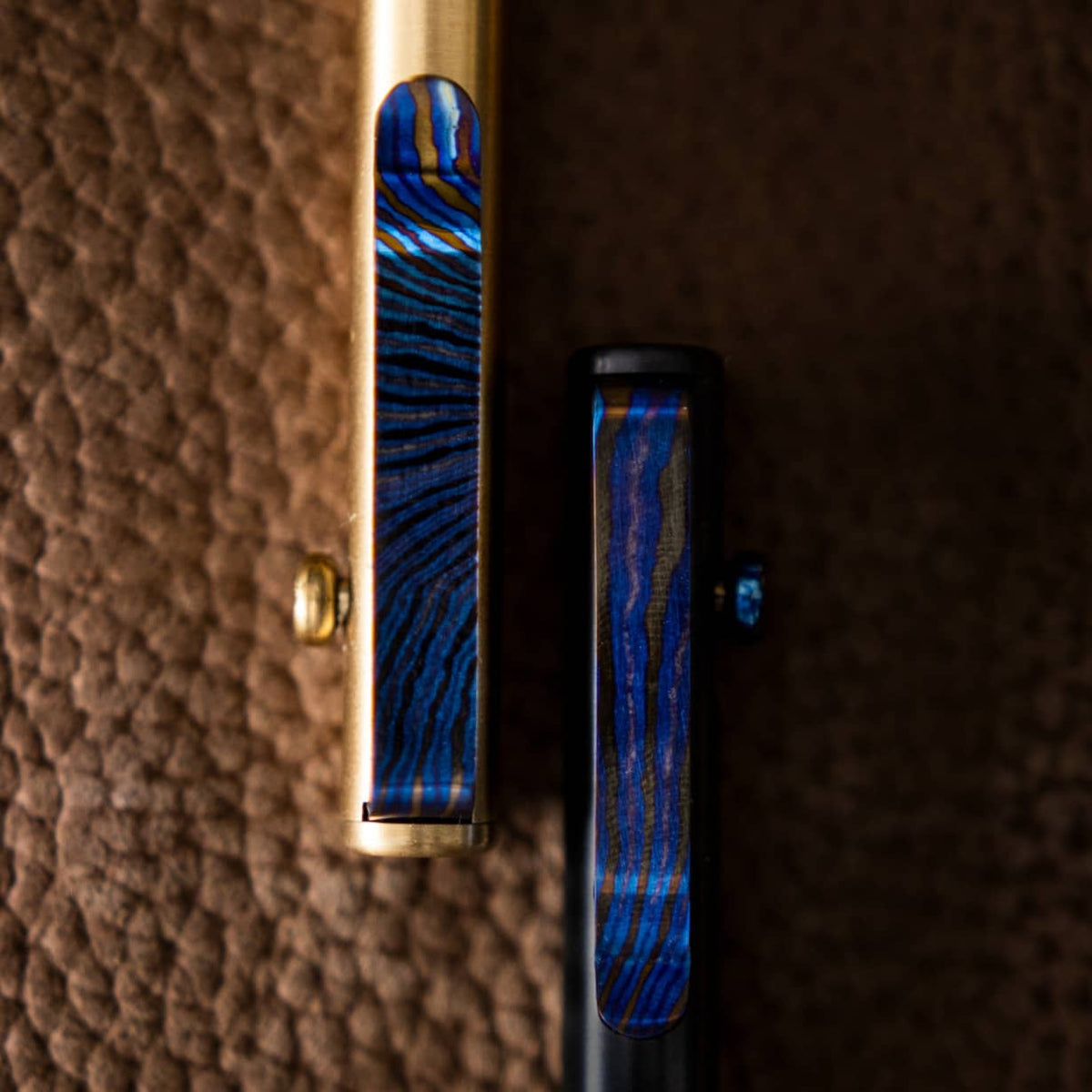 Big Idea Design LLC pens featuring a unique Titanium Damascus pen clip with blue and black patterns