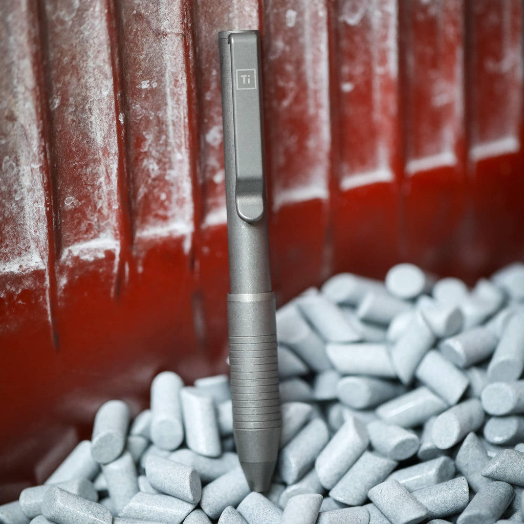USA Ti Pocket Pro Titanium Pen with Ergonomic Grip and Sleek Design on Gray Surface